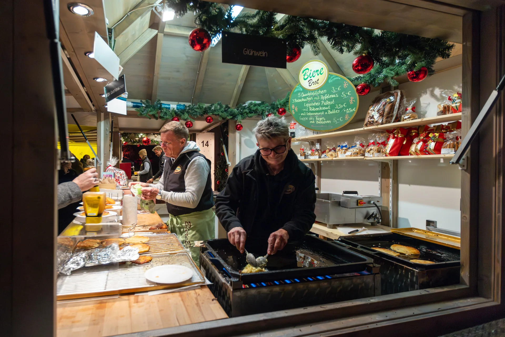 Grillstand auf dem Weihnachtsmarkt Frische Zubereitung von Speisen auf dem Grill eines Weihnachtsmarktstands.